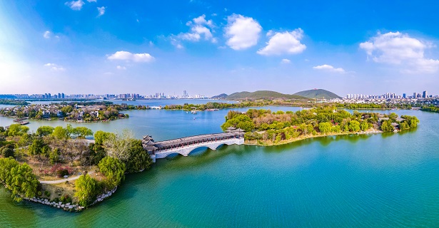 云龙湖是国家5a级景区，与西湖是姊妹湖，三面环山，一面临城，宛若一颗明珠镶嵌在徐州市中心。湛蓝天空下，湖光潋滟，绿木掩映，一湖碧水倒映着青山与城市远景，让人流连忘返。图为云龙湖泛月桥。孙博宇 摄_proc.jpg